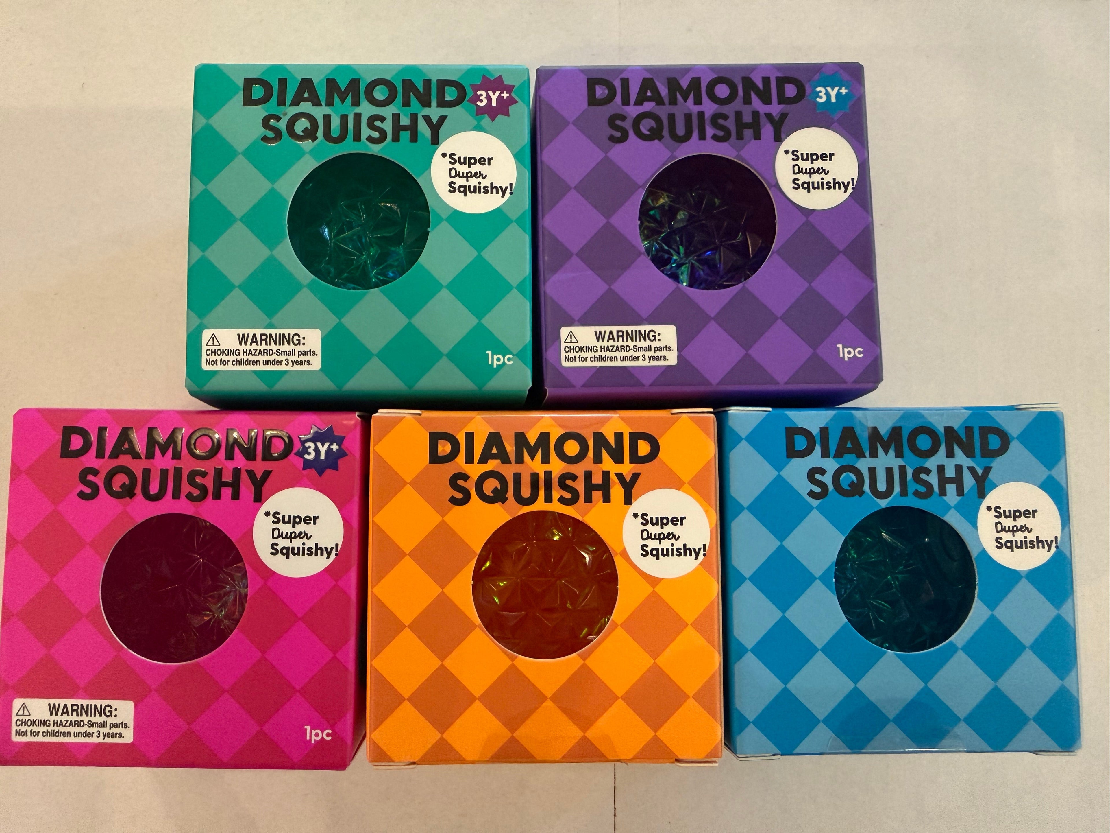Five Diamond Squishy packaging boxes in different colors on a beige background
